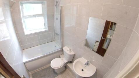 A clean and modern bathroom featuring a bathtub...