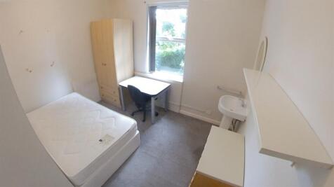 A compact single bedroom featuring a bed, a sma...