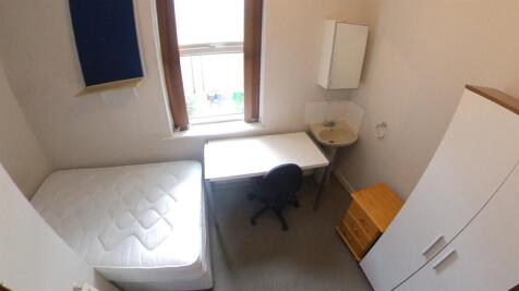 A bright and tidy single bedroom featuring a ne...