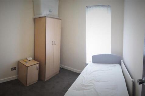 A modest single bedroom featuring a neatly made...