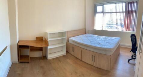 A well-lit bedroom featuring a spacious double ...