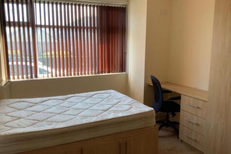 A cozy bedroom featuring a single bed, a window...