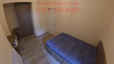 A cozy bedroom with a single bed, featuring woo...