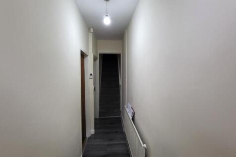 Bright, neutral-painted hallway with carpeted s...