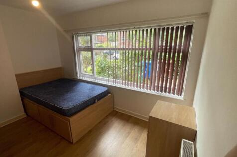 A bright double bedroom featuring a comfortable...