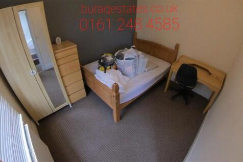 Cozy single bedroom featuring a wooden bed fram...