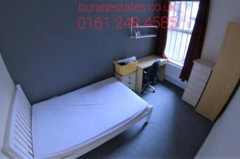 A cozy single bedroom featuring a neat bed fram...