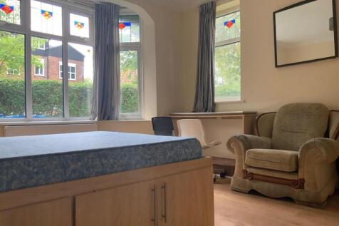 A well-lit, tidy living room featuring large wi...