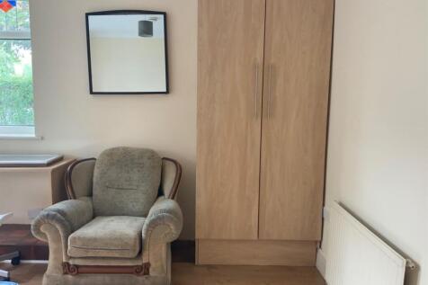 A cozy living room featuring a comfortable armc...