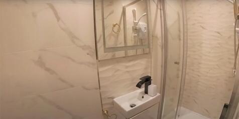 A modern bathroom featuring a spacious shower a...