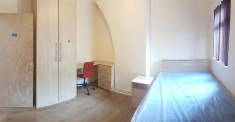 A well-lit, clean bedroom featuring a single be...