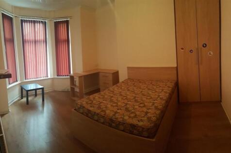 A cozy single bedroom with a bed situated again...