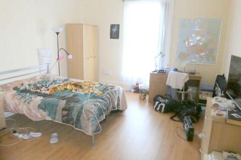 A spacious and well-lit bedroom featuring a lar...