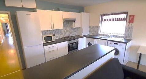 A modern, well-lit kitchen area featuring white...