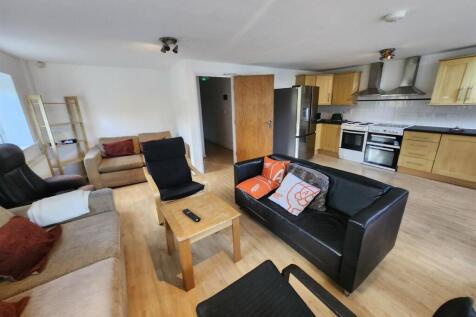 A spacious, well-maintained living room with pl...