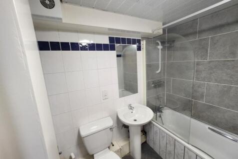 A well-maintained bathroom featuring a bathtub ...
