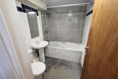 A clean and modern bathroom featuring a bathtub...