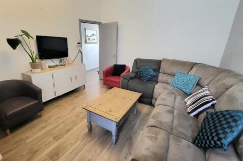 A spacious, modern living room featuring a larg...