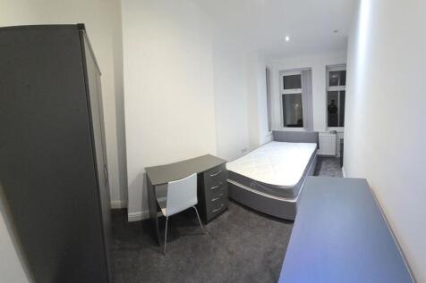 A bright and tidy bedroom featuring a comfortab...