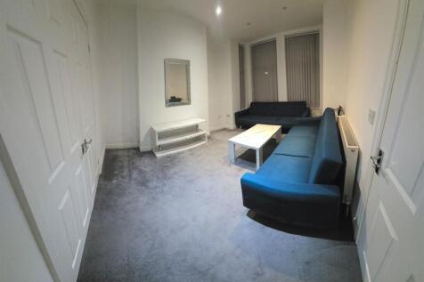 A modern living room with a blue sofa, white co...