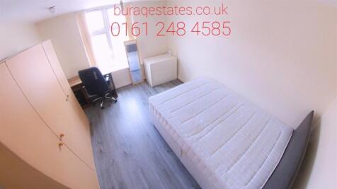 A cozy single bedroom featuring a neatly made b...