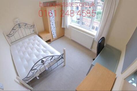 A cozy bedroom featuring a single bed with a de...