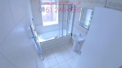 Bright and clean bathroom suite featuring a lar...