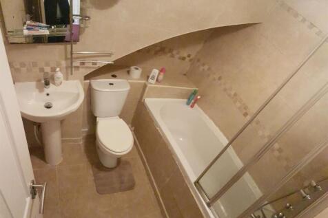 A modern and clean bathroom featuring a bathtub...