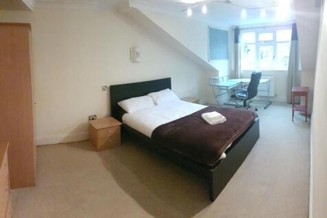 A spacious master bedroom featuring a large bed...