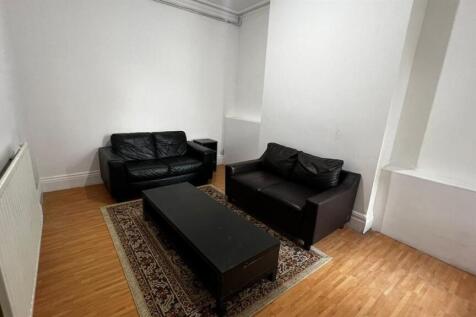 A cozy living room featuring two black sofas ar...