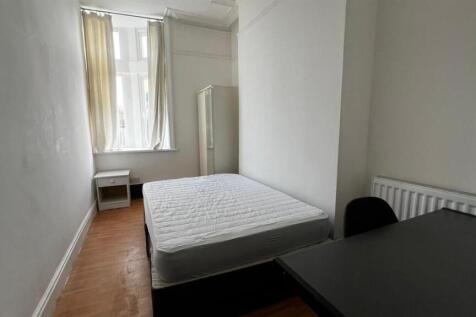 A simple and tidy single bedroom featuring a be...