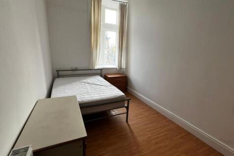 A simple single bedroom featuring a single bed ...