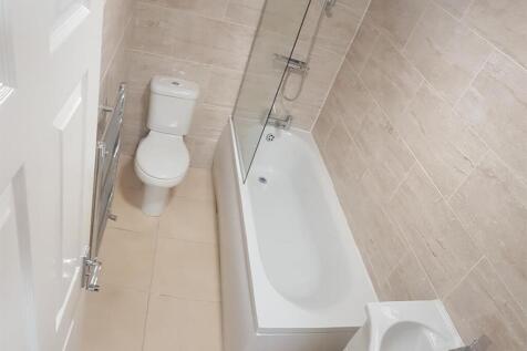 A clean and modern bathroom with a bathtub, a t...