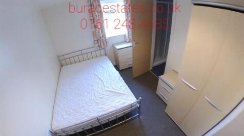 A tidy single bedroom featuring a neatly made b...