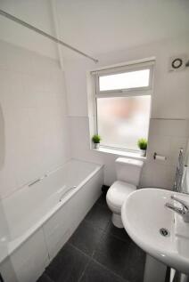 Bright and clean bathroom suite featuring a ful...