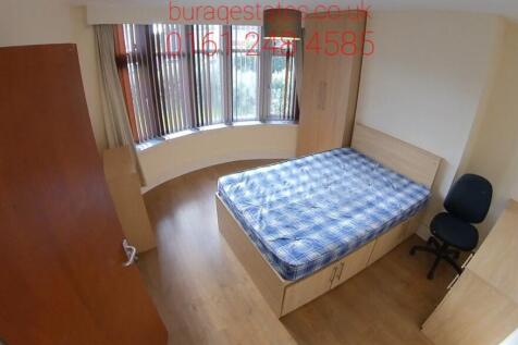 A well-lit single bedroom featuring a bed with ...