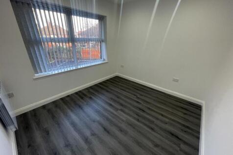 A bright and clean bedroom with a large window ...
