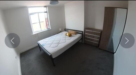 A tidy double bedroom featuring a large window ...