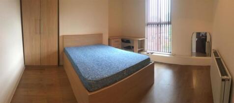 Bright, simply furnished bedroom with a double ...