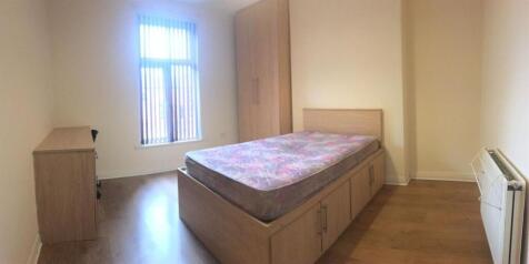 Bright, simply furnished bedroom with a double ...