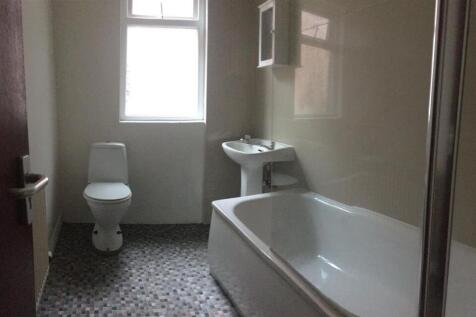 Clean, modern bathroom with a bathtub and separ...