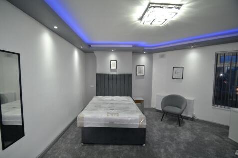 Stylish double bedroom with a plush grey uphols...