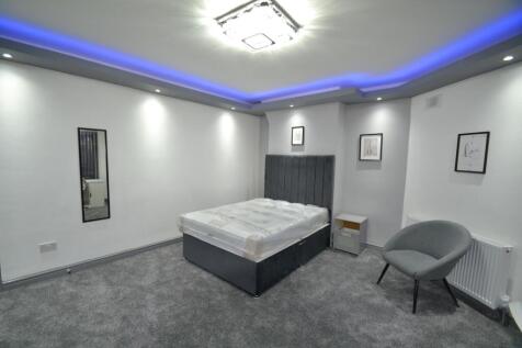 Contemporary double bedroom with a grey upholst...