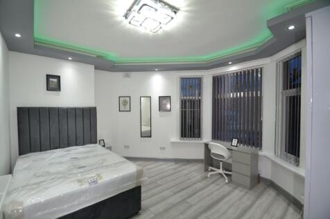 Bright, modern double bedroom with a tall uphol...