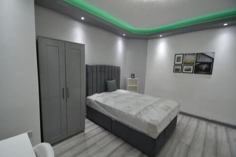 Bright, contemporary bedroom with a grey uphols...
