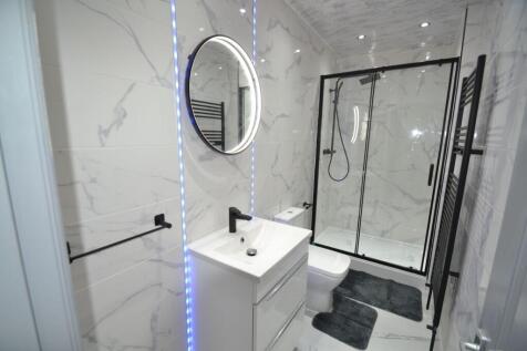 Contemporary marble-tiled bathroom with a walk-...