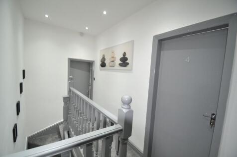 Bright, freshly painted hallway with grey doors...