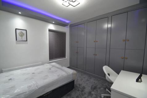 Modern double bedroom with built-in grey wardro...