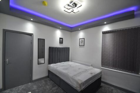 Modern double bedroom with a tall upholstered h...