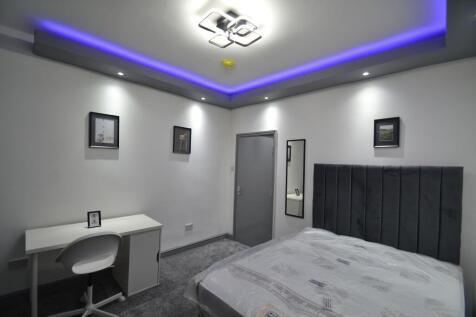 Modern, neatly presented bedroom with a grey up...